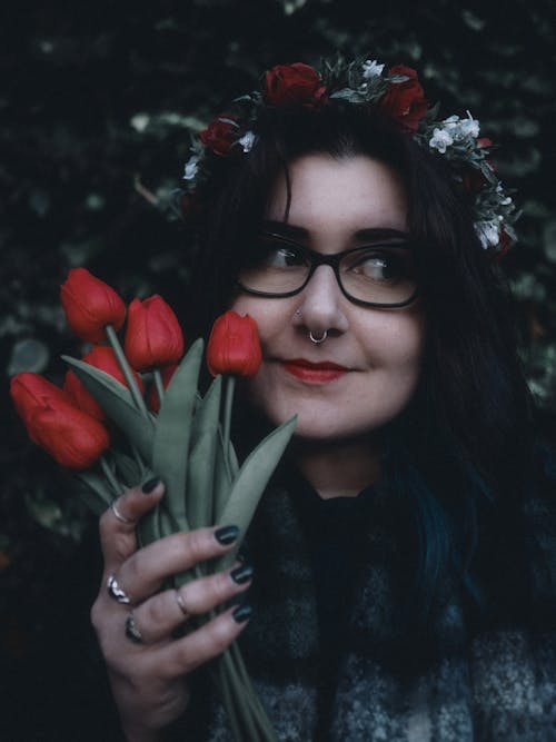 A woman with glasses and flowers in her hair