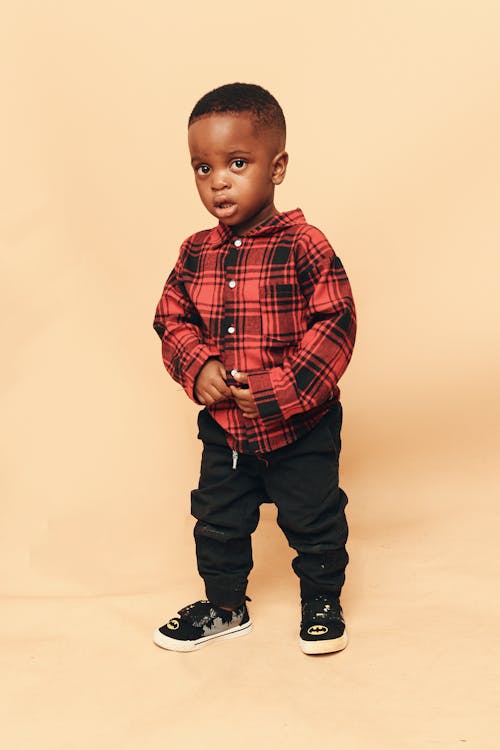 A young boy in a red and black plaid shirt
