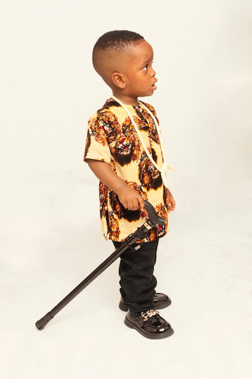 A young boy with a cane and a shirt