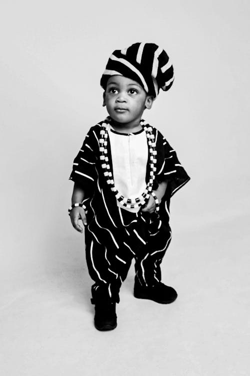 A black and white photo of a child wearing a hat