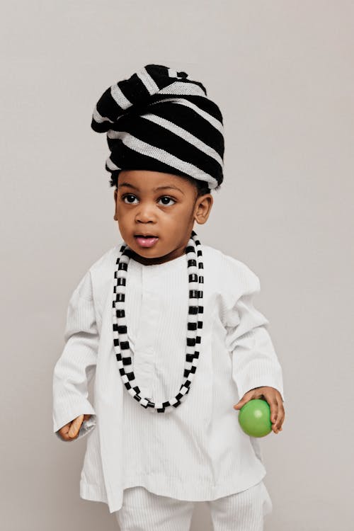 A young black child wearing a white and black outfit