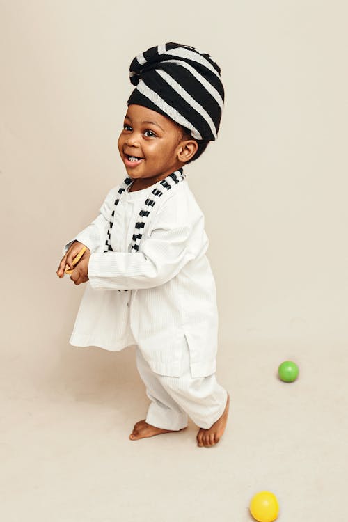 A baby in a white and black outfit with a hat