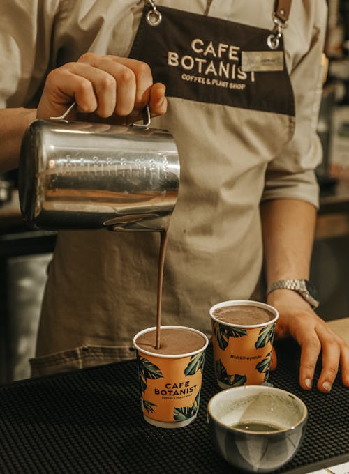 A man pouring coffee into cups at a cafe