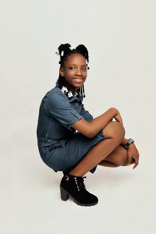 A young woman in a denim dress and black boots