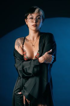 Confident woman posing in lingerie and bathrobe in studio setting.
