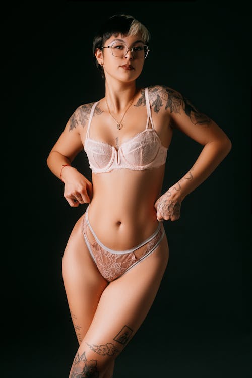 A woman with tattoos and a pink bra