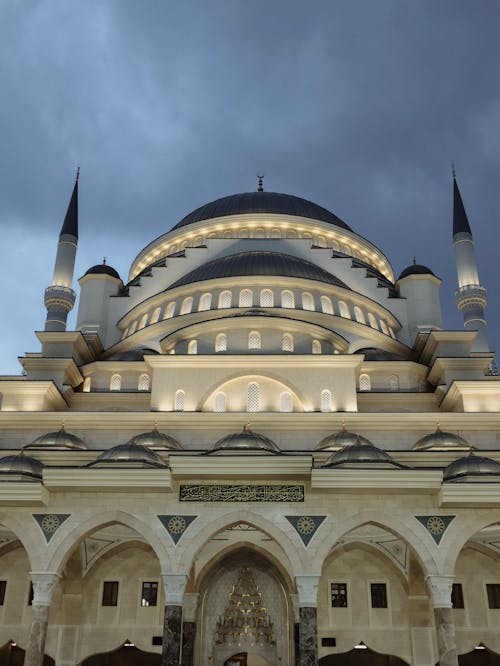 The white and blue mosque is lit up at night