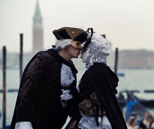Free A couple in elaborate costumes and masks share a tender moment in Venice. Stock Photo