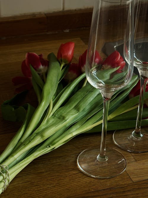 Two glass cups and a bouquet of red tulips