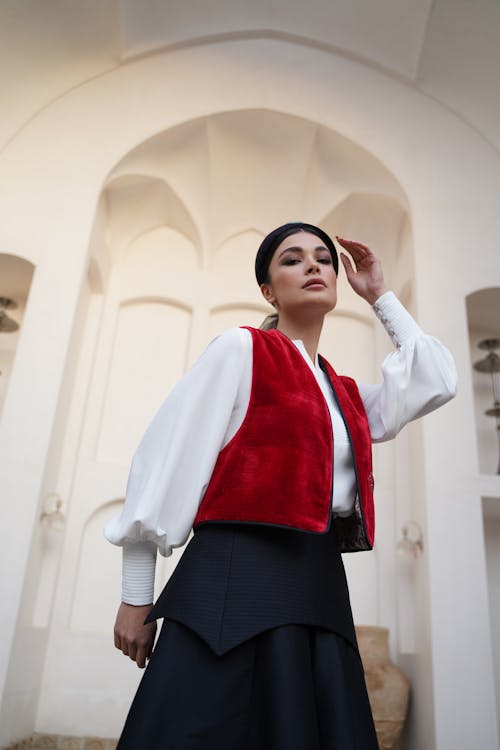 Foto profissional grátis de braço levantado, colete vermelho, de pé