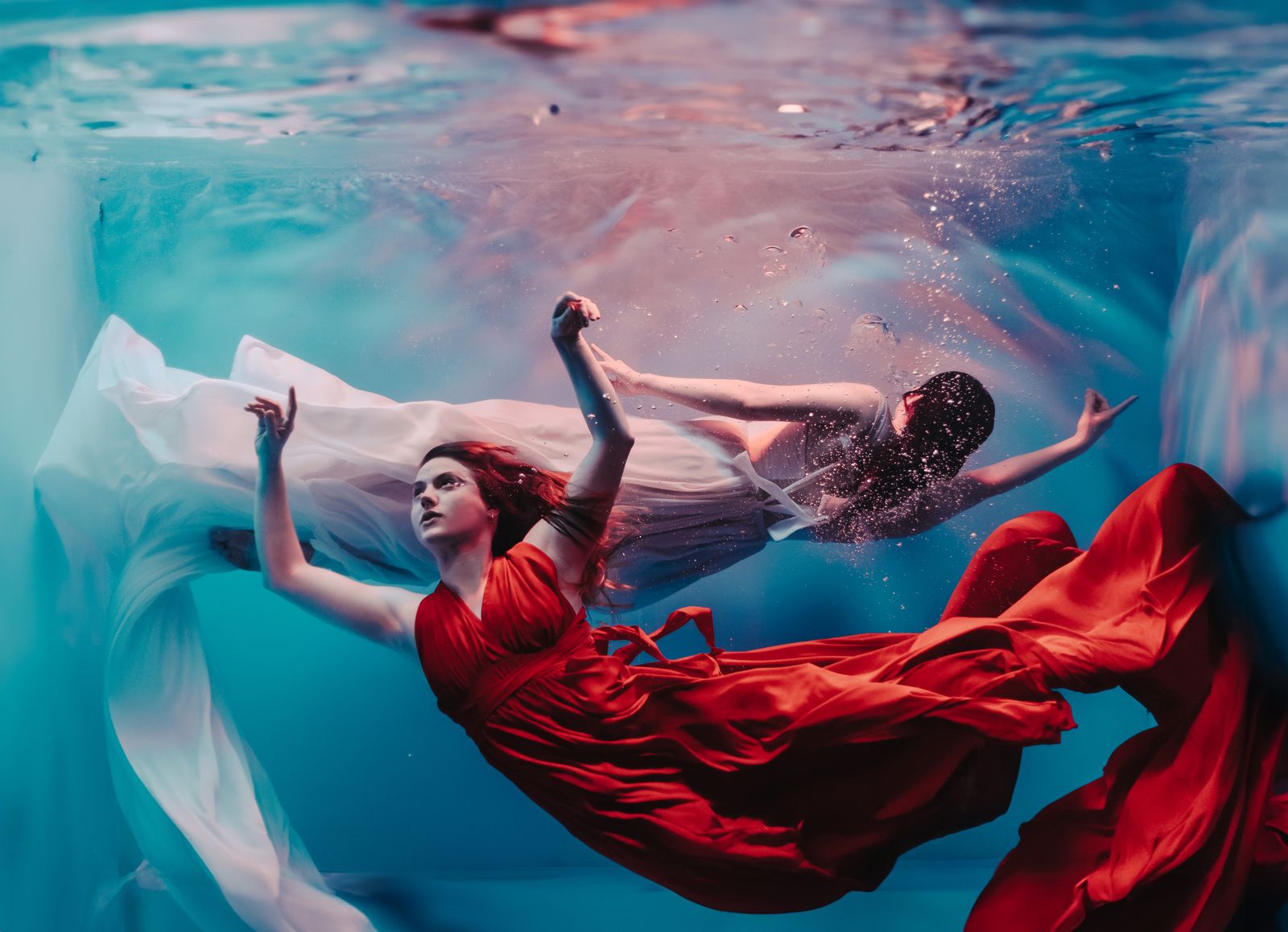 Underwater senior portrait in flowing red dress