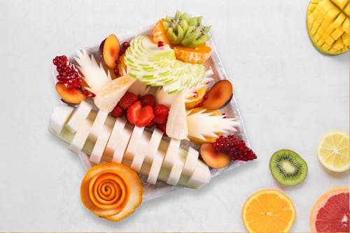 A fruit platter with sliced fruit and a slice of orange