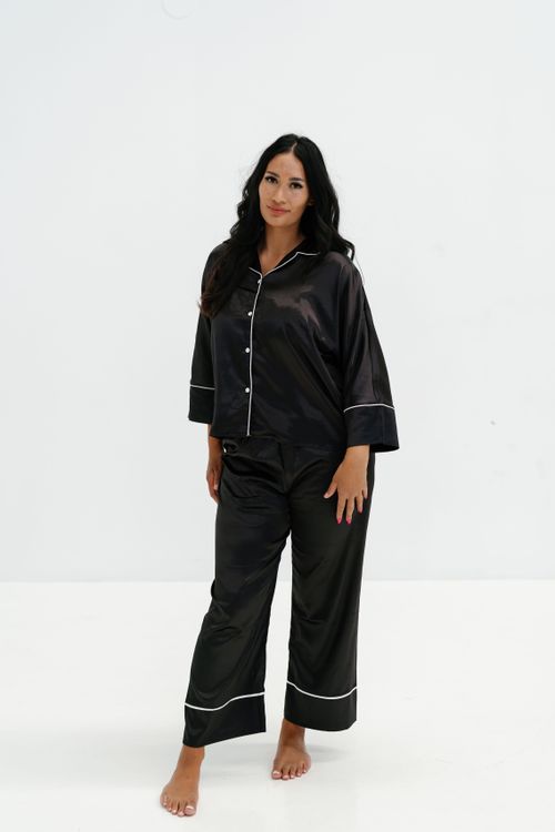 Free Fashion photography of a woman in black pajamas posing against a white backdrop. Stock Photo
