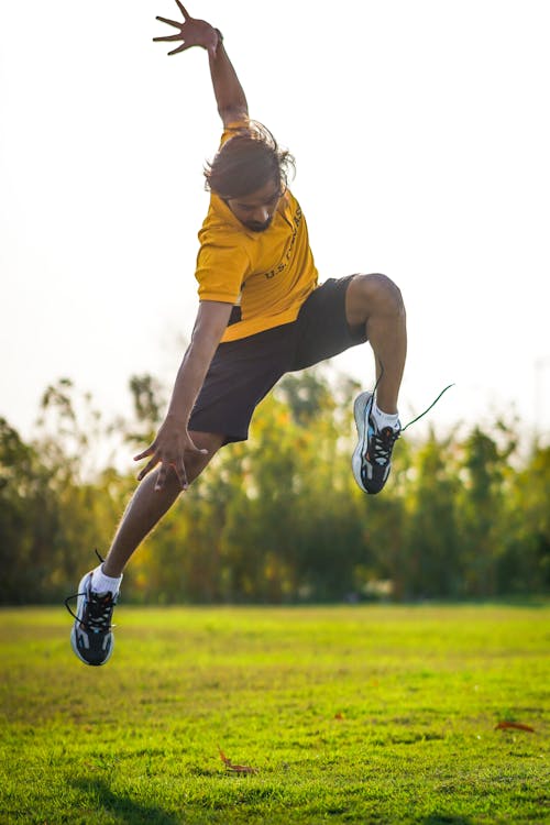 A young man is jumping in the air with a frisbee