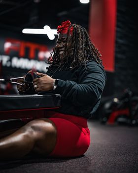 Black woman enjoying a workout session in a modern gym, focusing on fitness and strength.