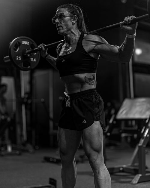 Free Black and white photo of a muscular woman lifting weights at a gym, showcasing strength and dedication. Stock Photo