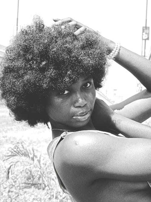 A black and white photo of a woman with afro hair
