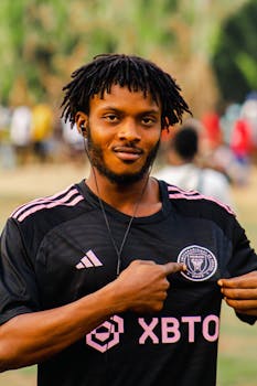 Portrait of a soccer player in an Inter Miami jersey, standing outdoors.