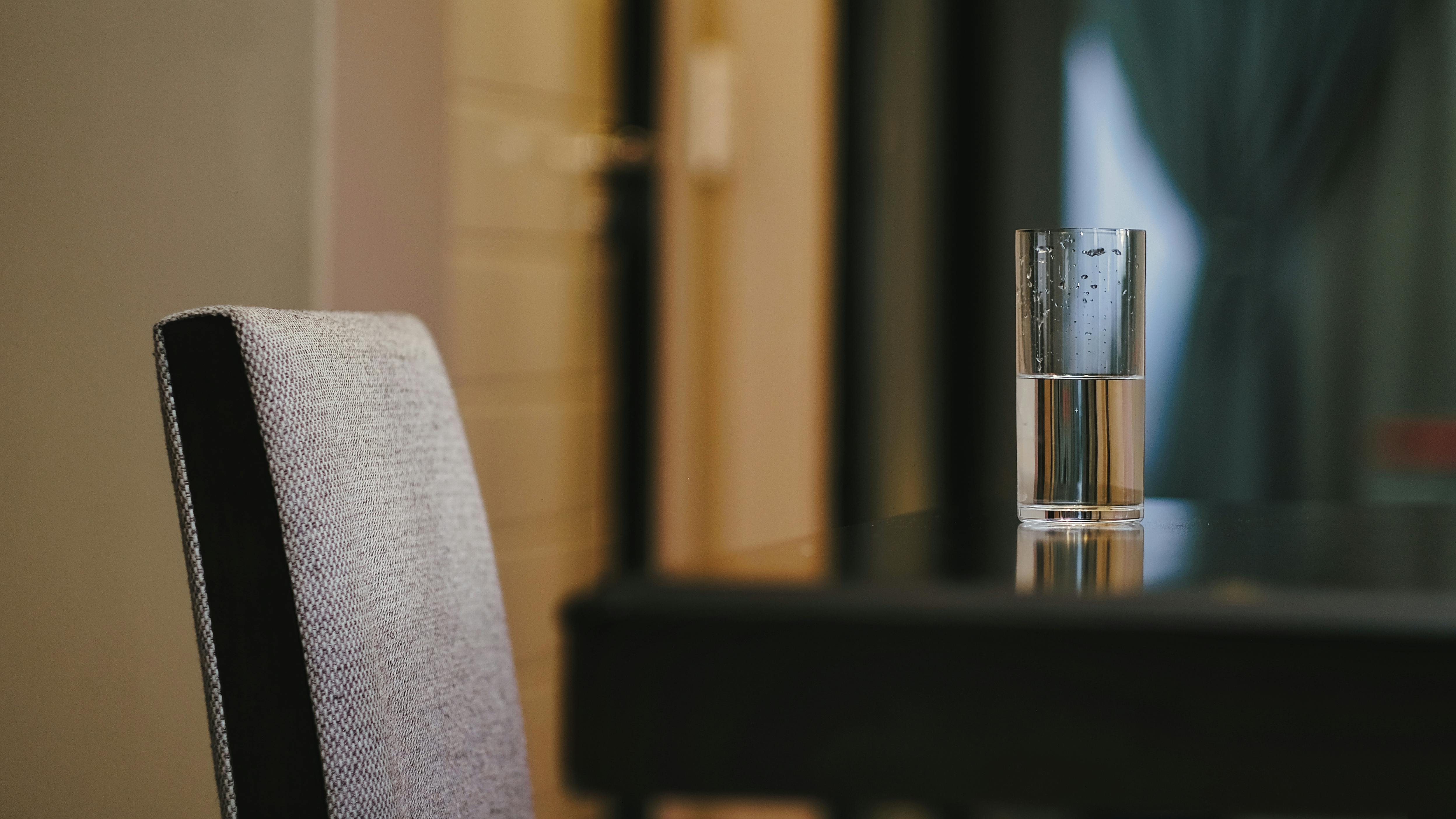 A stylish dining setup featuring a glass of water on a sleek table. Perfect for modern interiors.