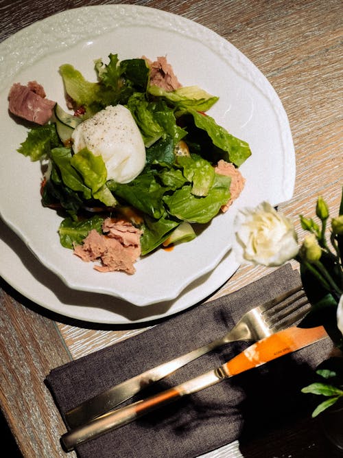 A plate with lettuce, a fork and a knife