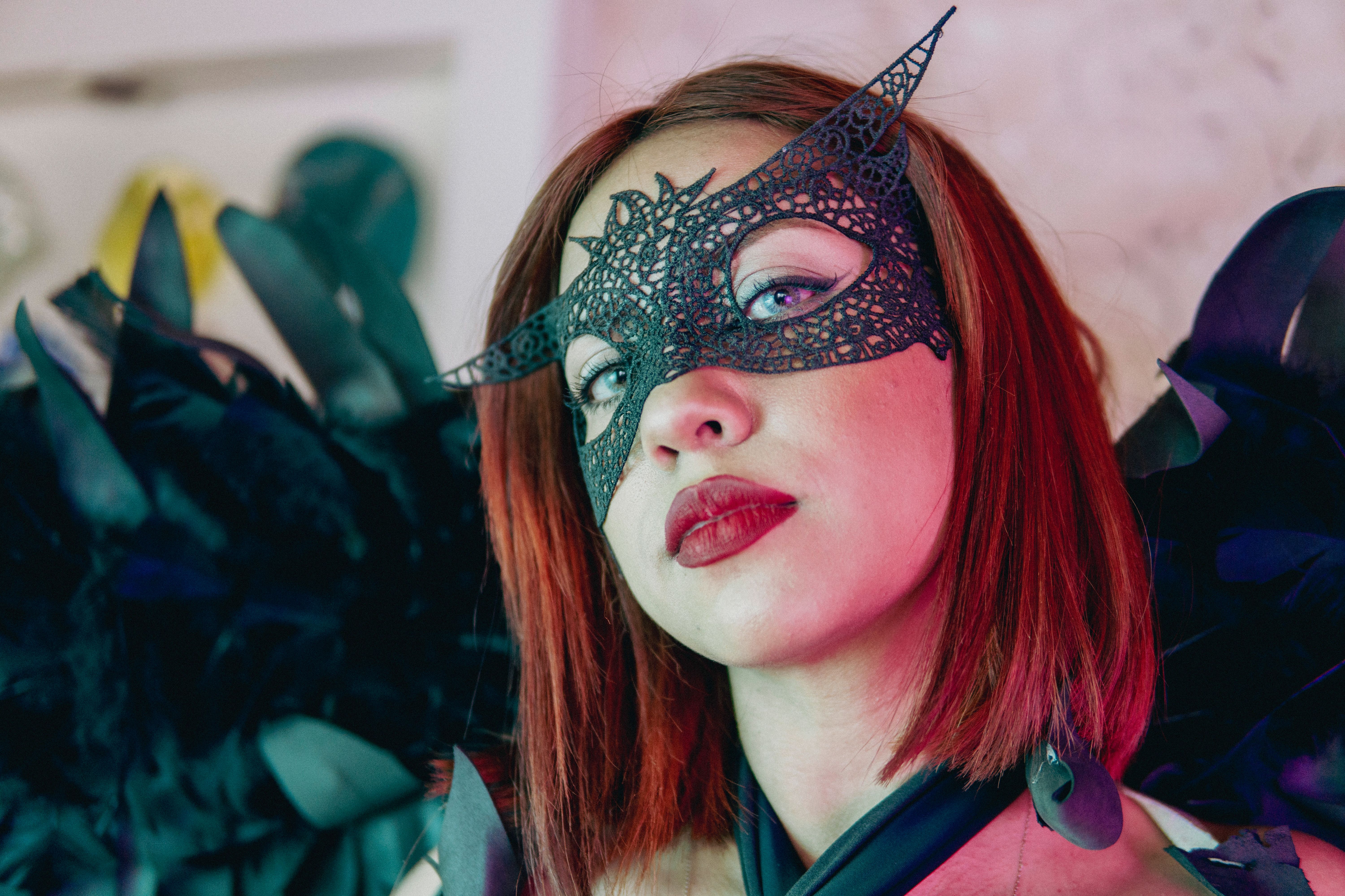 A woman with black feathers and a mask