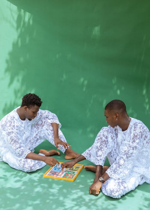 Men in White Clothes Sitting and Playing Board Game