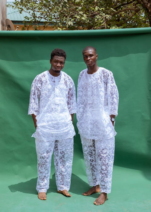 Two men in white clothes standing next to each other