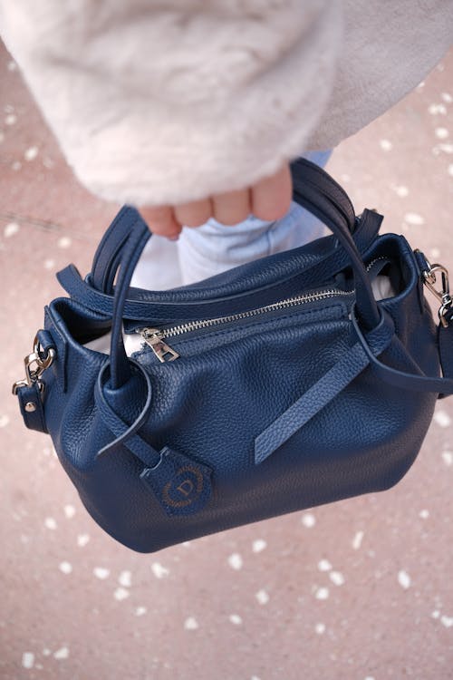 Hand Holding a Blue Handbag