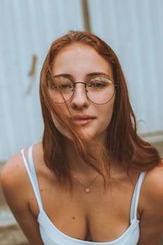 一位戴眼镜的红发年轻女子的特写肖像，时尚感十足