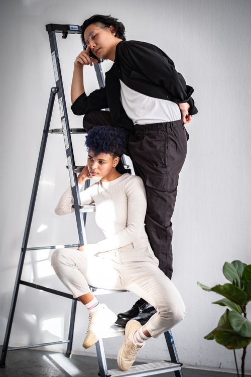 Free Fashion models posing on a ladder in a Berlin studio with a minimalist white background. Stock Photo