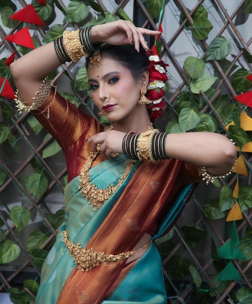 A beautiful woman in a blue and gold sari