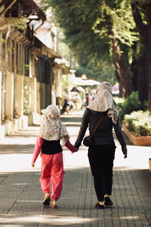 Free Two women walking down a street with the words, the best way to learn about islam is to live it Stock Photo