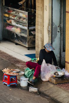 Street vendor preparing food on a sidewalk, showcasing urban life and street food culture.