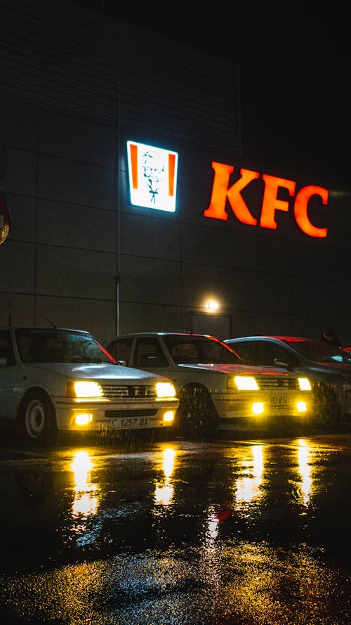 A group of cars parked outside a kfc restaurant