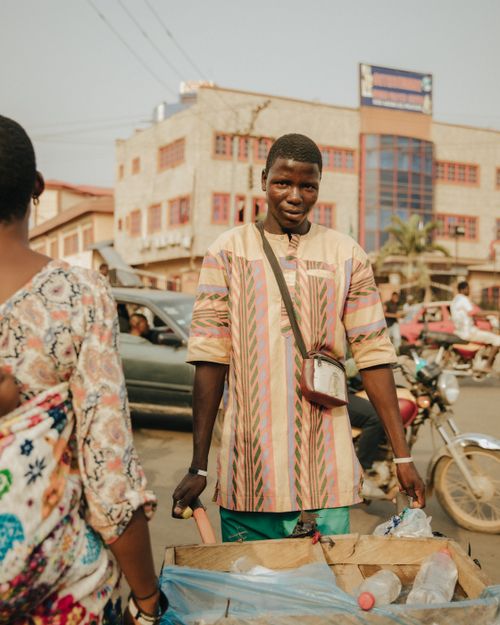 Free A local vendor standing with his cart on a bustling city street, conveying everyday life. Stock Photo