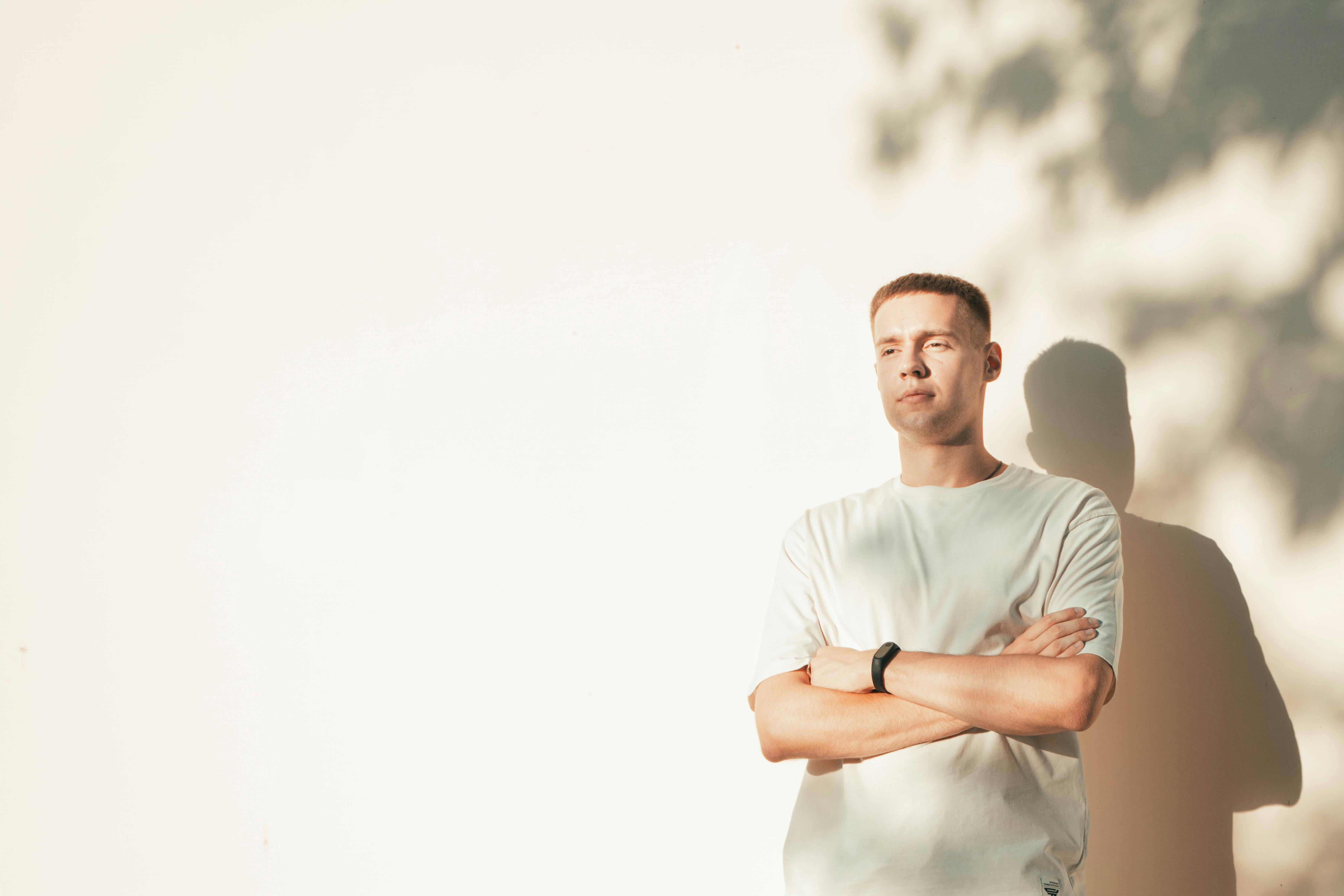 Portrait of a young boy with his arms crossed on his chest in the soft shadows of the setting sun
