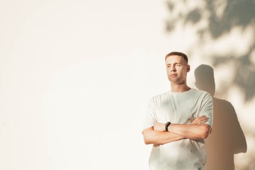 portrait of a young boy with his arms crossed on his chest in the soft shadows of the setting sun