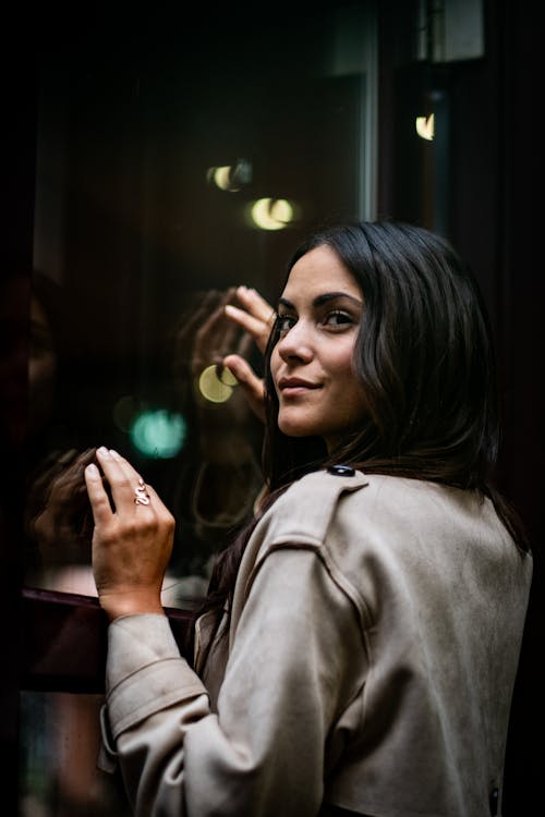 A woman looking at her reflection in a window