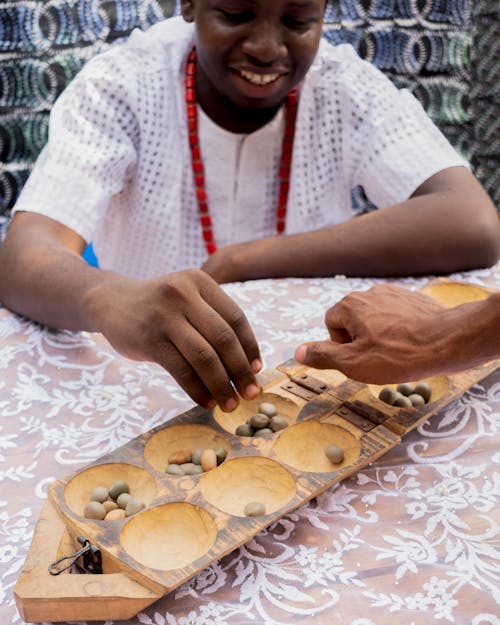 Gratis lagerfoto af afrikansk mand, bord, hænder