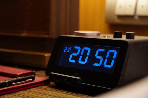 A digital alarm clock sitting on a table