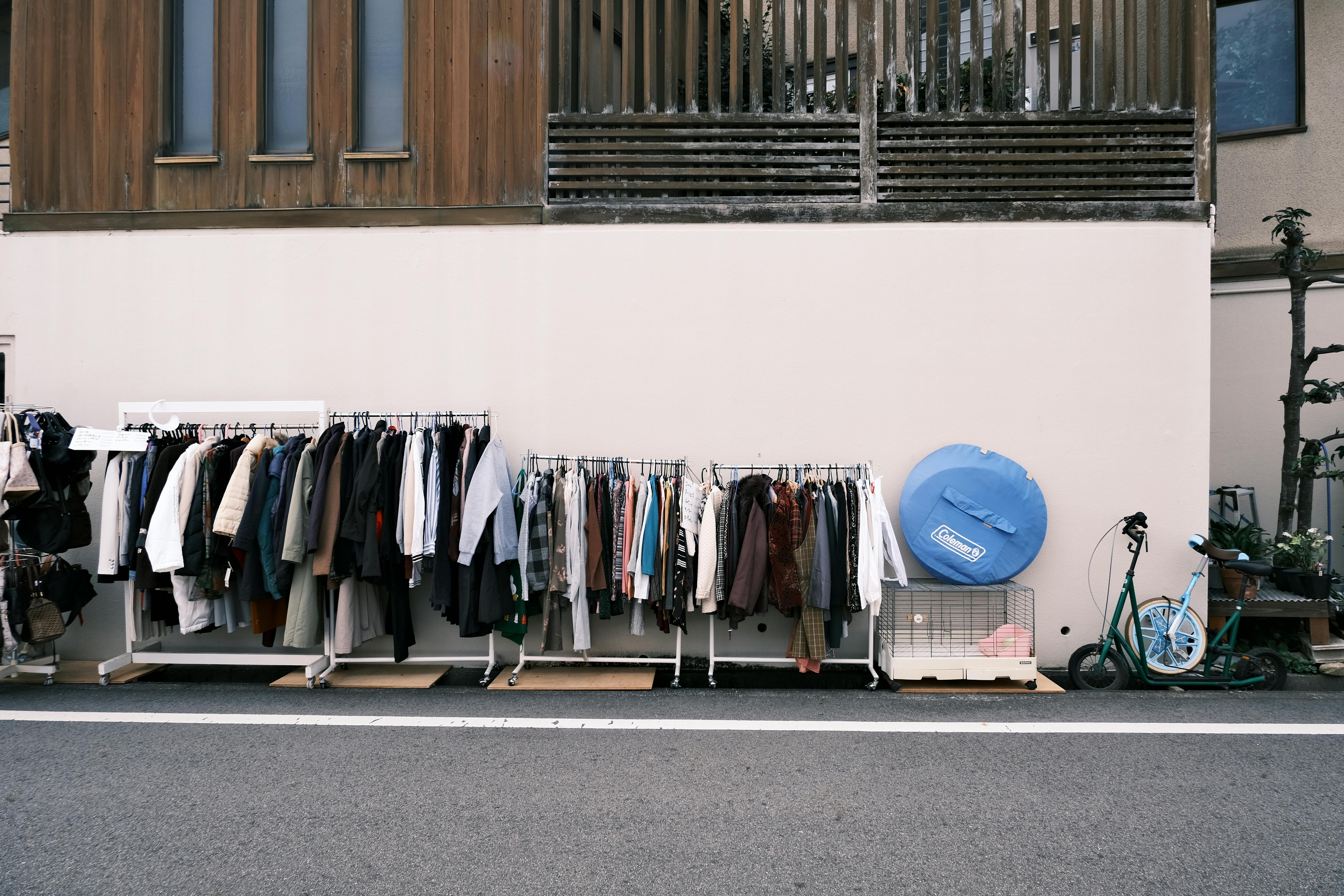 Street view of clothing racks outside a building in Okazaki, Japan. Urban, cultural scene.