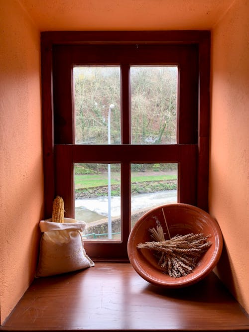 A window with a bowl and a basket on it