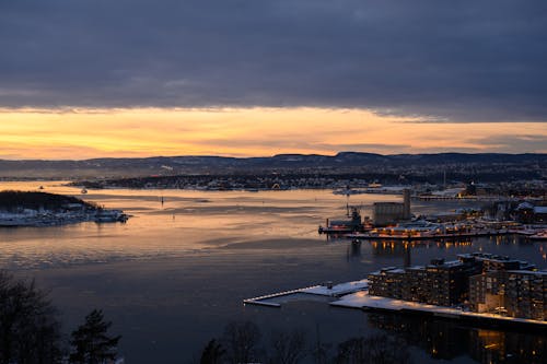 A view of a city at sunset with snow on the ground