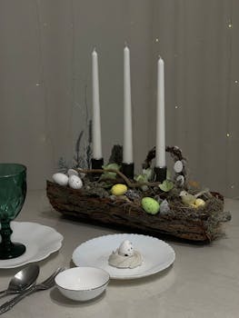 Elegant Easter table setup with candles, eggs, and decorative centerpiece.
