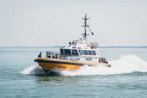 Free A powerful pilot boat cutting through the water at speed on a clear day in the ocean. Stock Photo