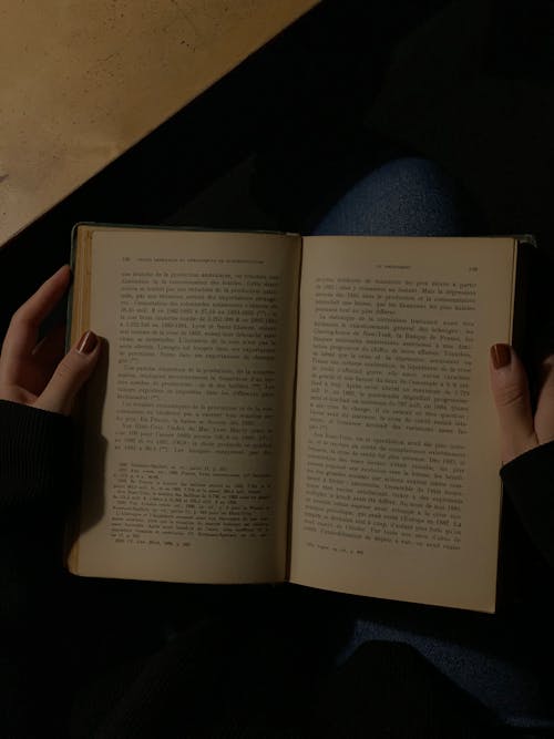 A person holding an open book in their hands