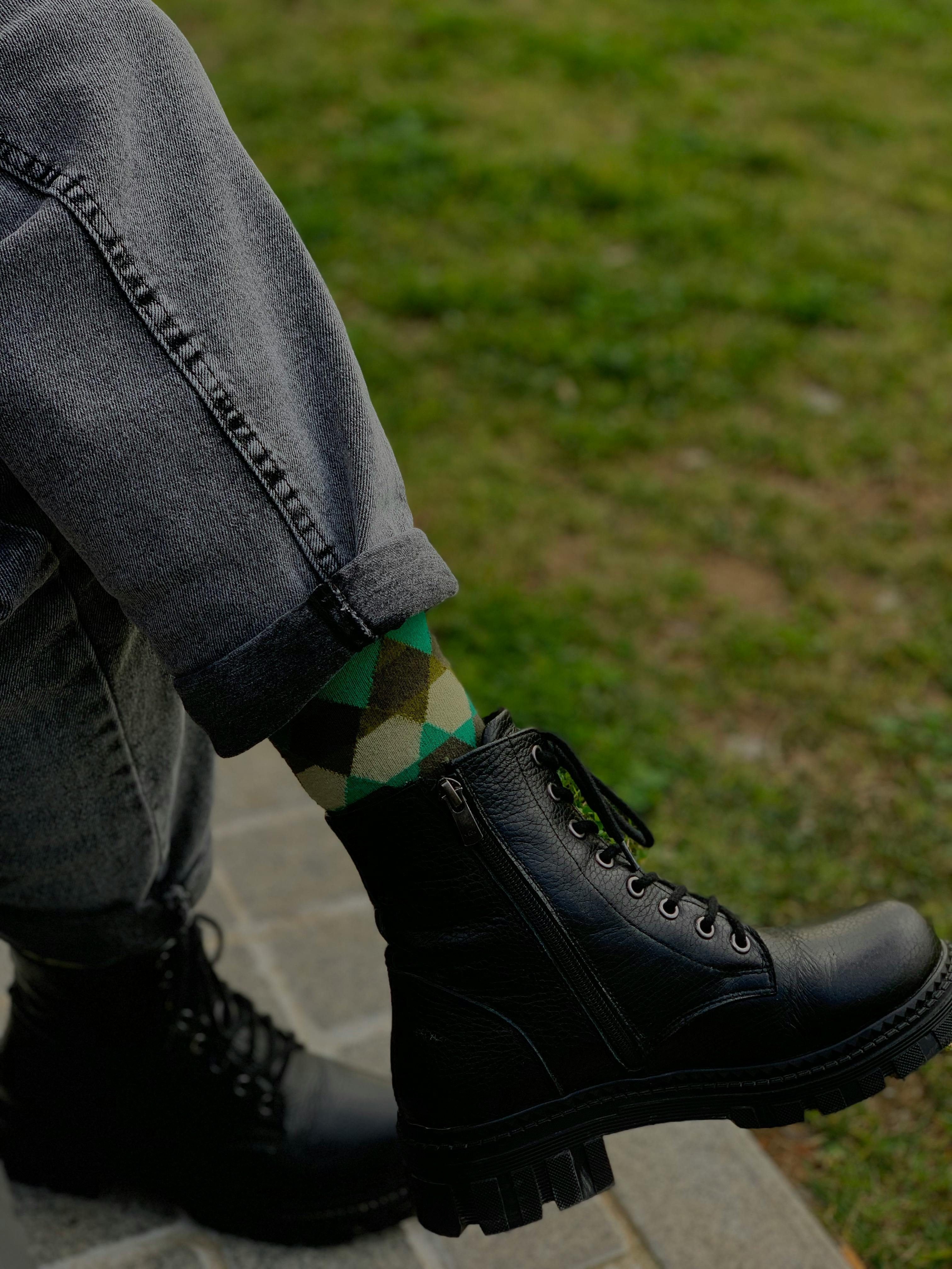 Trendy boots with patterned socks and jeans on a park bench in Istanbul, Türkiye.