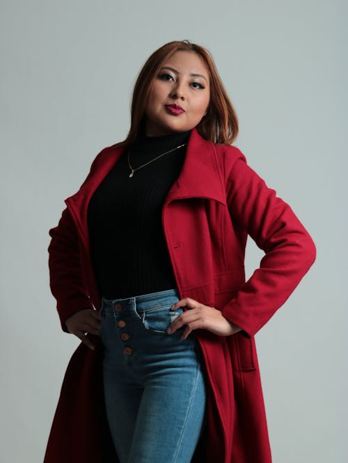 A woman in a red coat posing for a photo