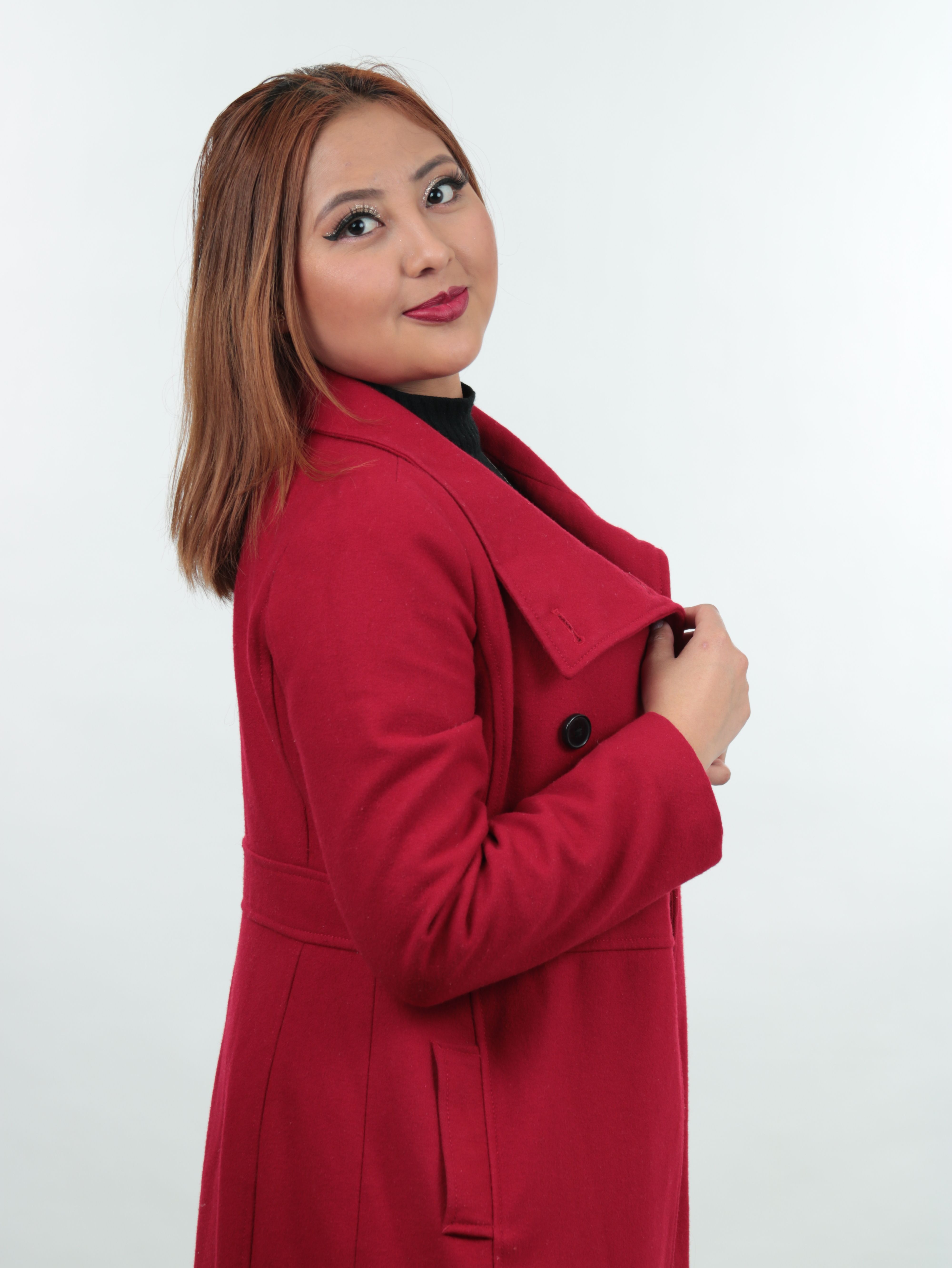 Portrait of a fashionable woman with brown hair in a red coat, showing elegance.