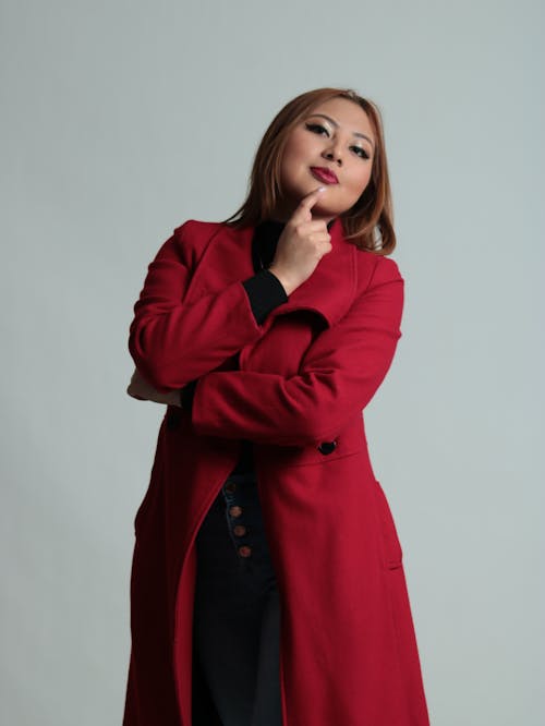 Standing Model Woman in Red Coat in Thinking Pose